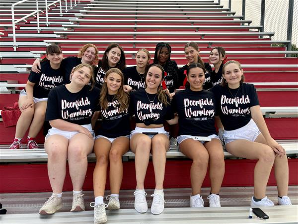 Cheerleaders sitting in the stands watching football